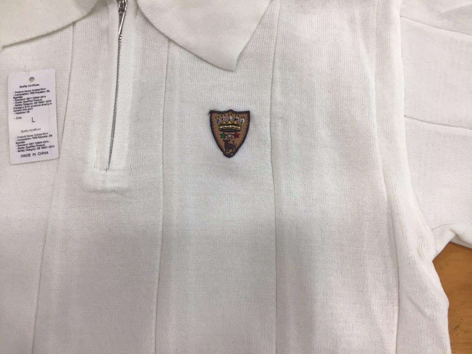Polo uomo Bolgi in maglia effetto seta color ghiaccio, con zip frontale e logo ricamato, indossata in look estivo elegante e moderno.