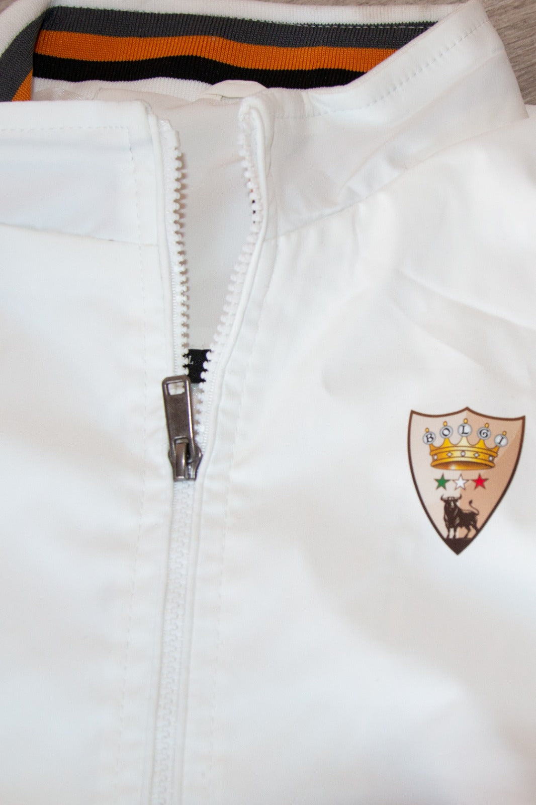 Giubbotto trench estivo da uomo Bolgi, bianco con colletto alto e dettagli a righe, indossato su outfit casual.