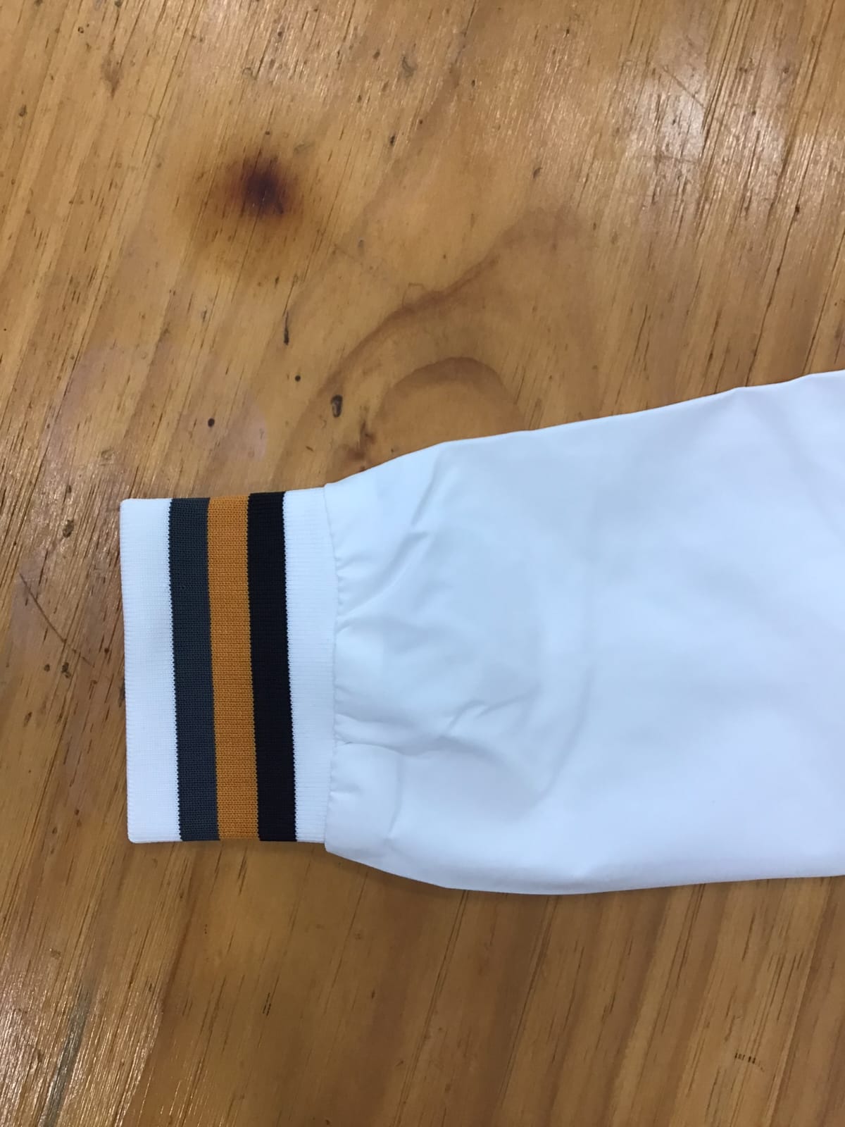 Giubbotto trench estivo da uomo Bolgi, bianco con colletto alto e dettagli a righe, indossato su outfit casual.