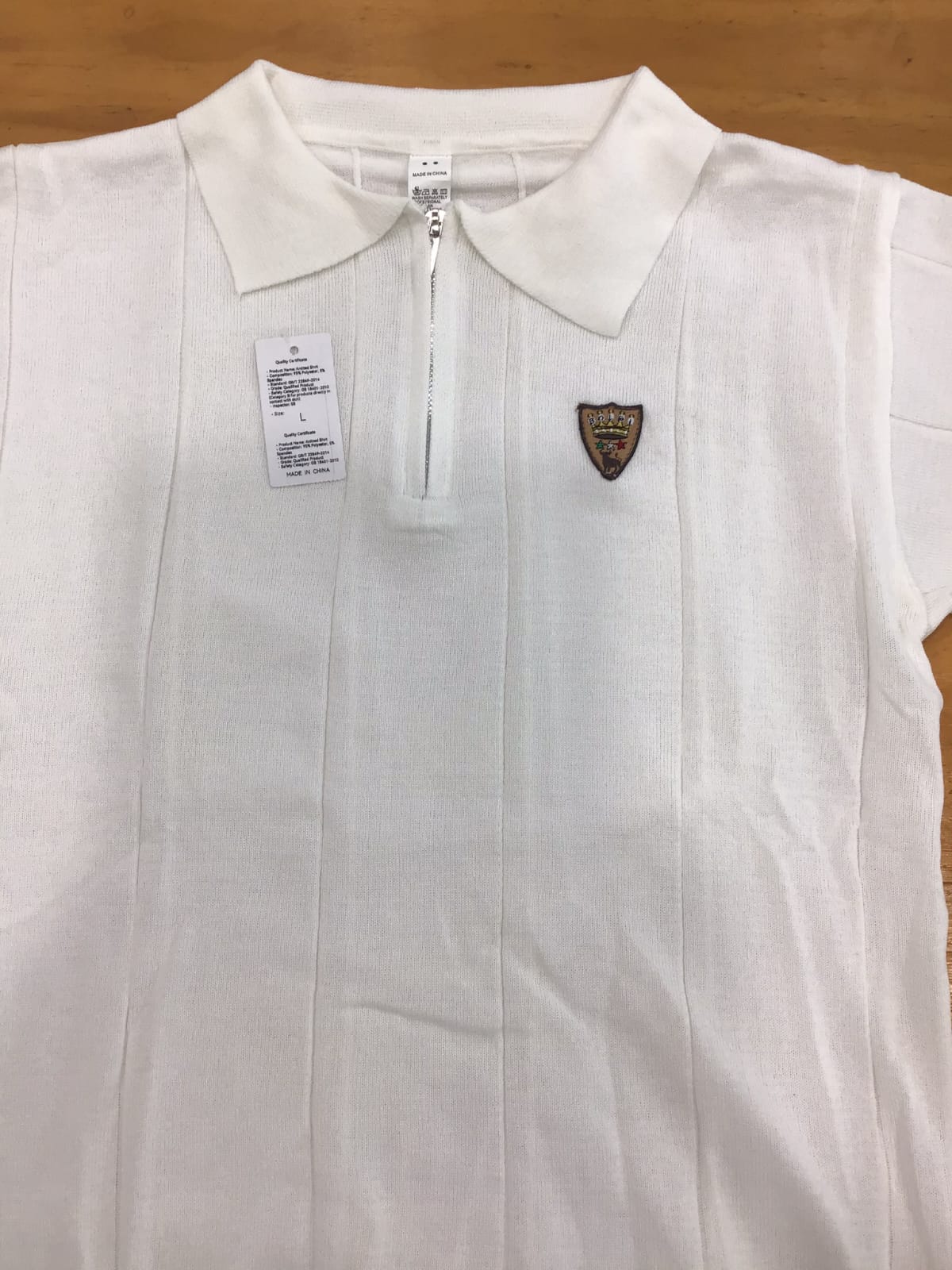 Polo uomo Bolgi in maglia effetto seta color ghiaccio, con zip frontale e logo ricamato, indossata in look estivo elegante e moderno.