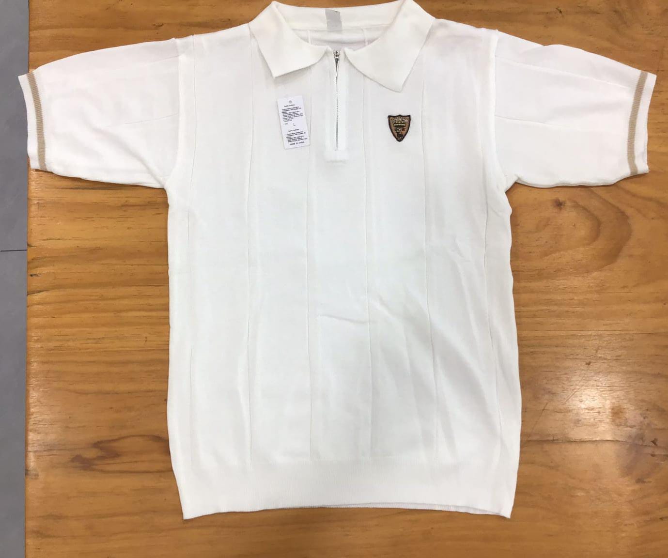 Polo uomo Bolgi in maglia effetto seta color ghiaccio, con zip frontale e logo ricamato, indossata in look estivo elegante e moderno.